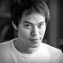 Photographic black and white portrait of Professor Kevin Fong showing his head and shoulders.