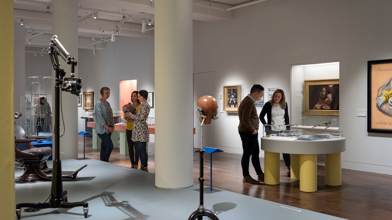 Photograph of visitors exploring the Teeth exhibition at Wellcome Collection.