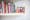 Photograph showing a shelf with a family photo in a frame of a mother and two small children. To the left of the photo is a collection of books.