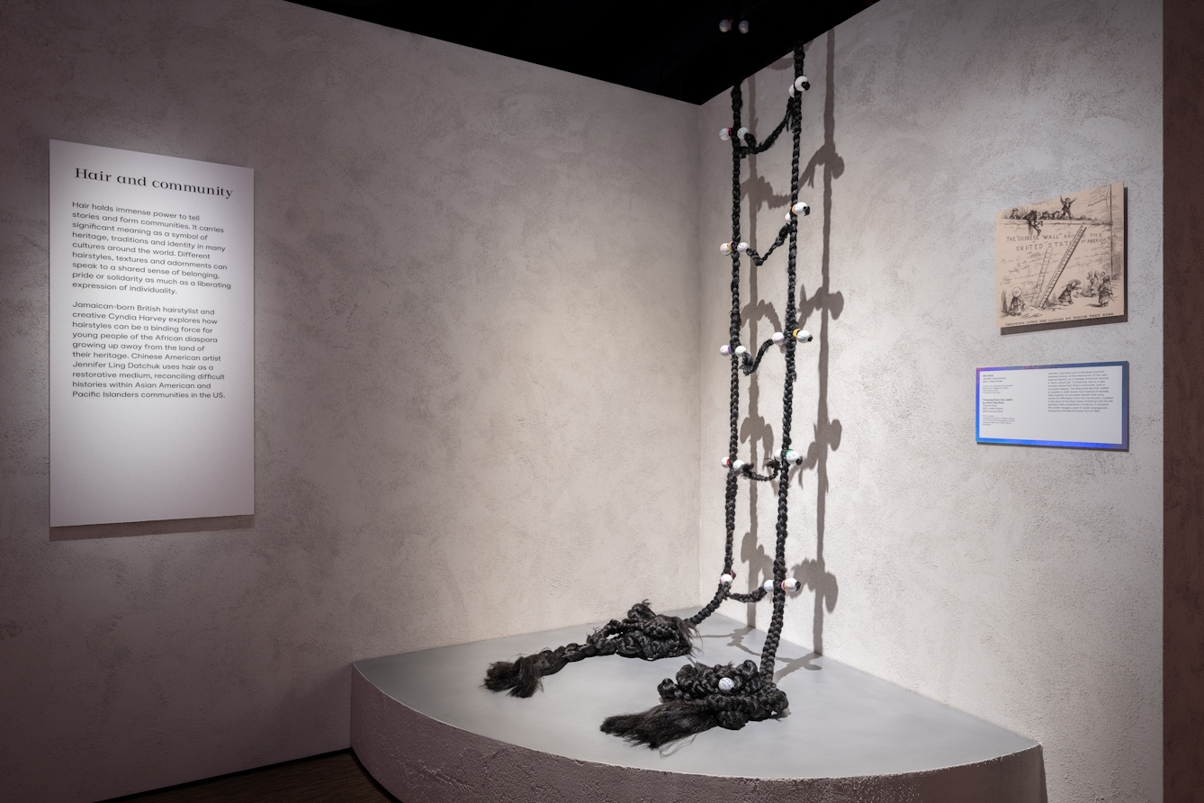 Photograph of an artist's gallery installation showing what looks like a rope ladder but which is made out of dark brown hair.