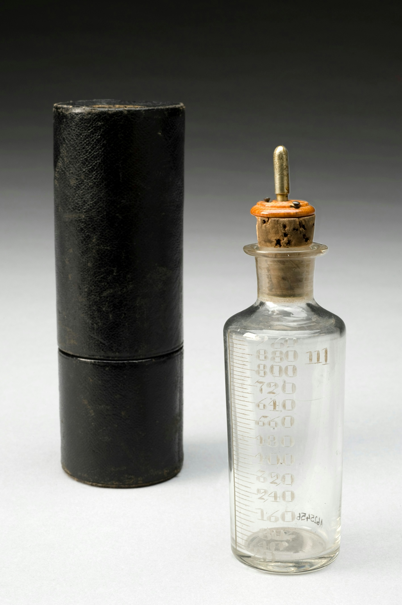 Colour photograph of a glass bottle and its case