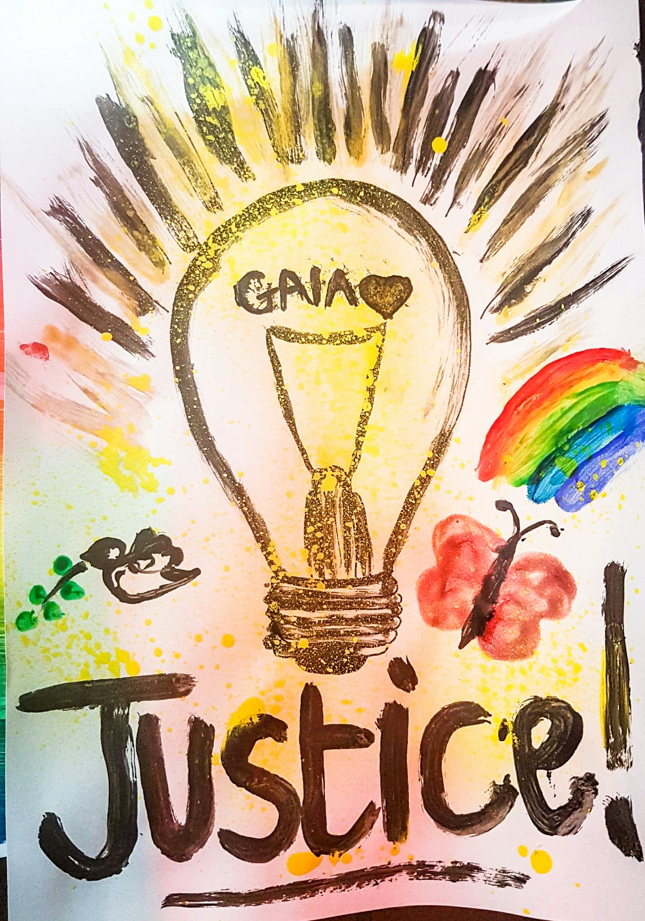 Photograph of an artwork depicting a light bulb withe the name Gaia inside, and the word ‘justice’ beneath. The light bulb is surrounded by a rainbow, a butterfly and a dove.