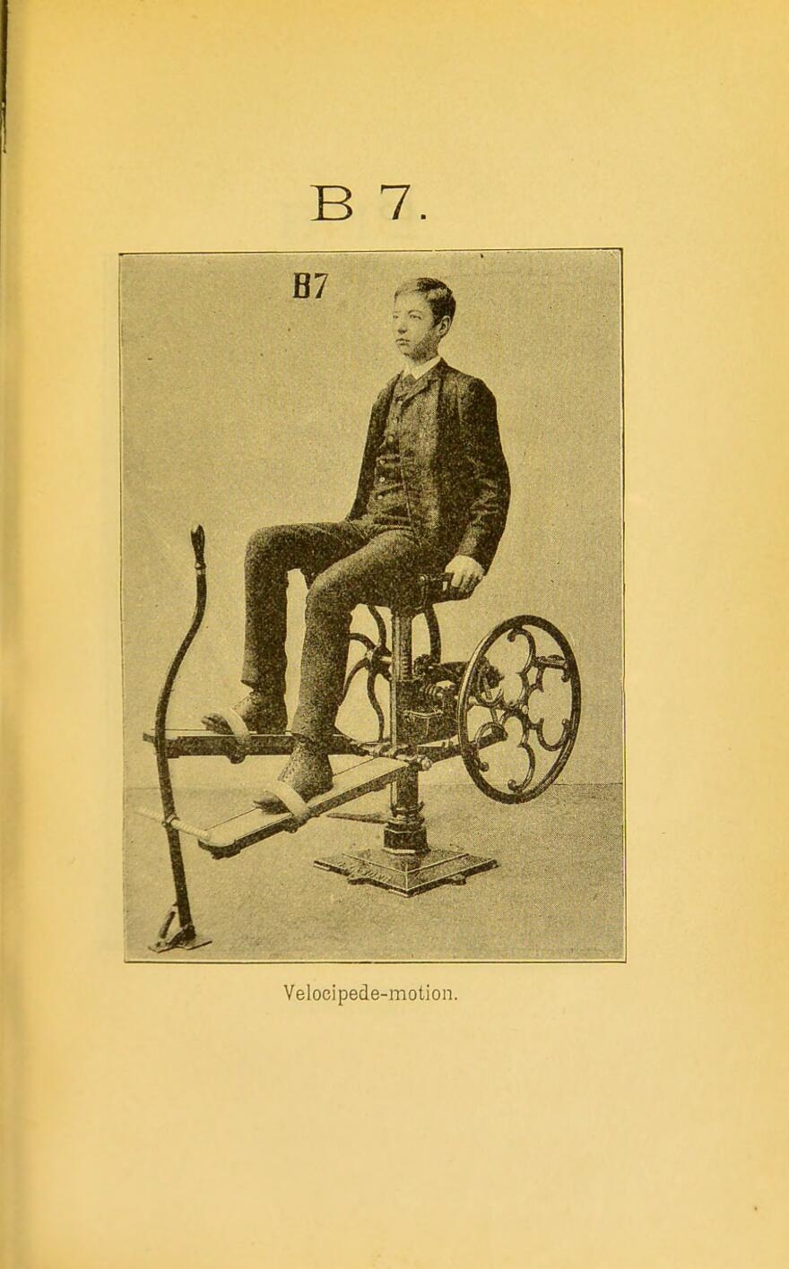 Black and white photograph from a book with yellowing pages showing a young man seated in a contraption with two wheels to each side of him, to which are affixed planks that his feet are strapped to for the purpose of exercise. Label reads "velocipede-motion".