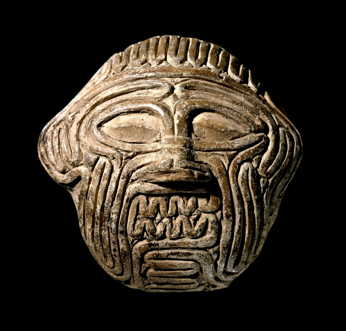An ancient Babylonian clay mask showing the face of the demon Humbaba.