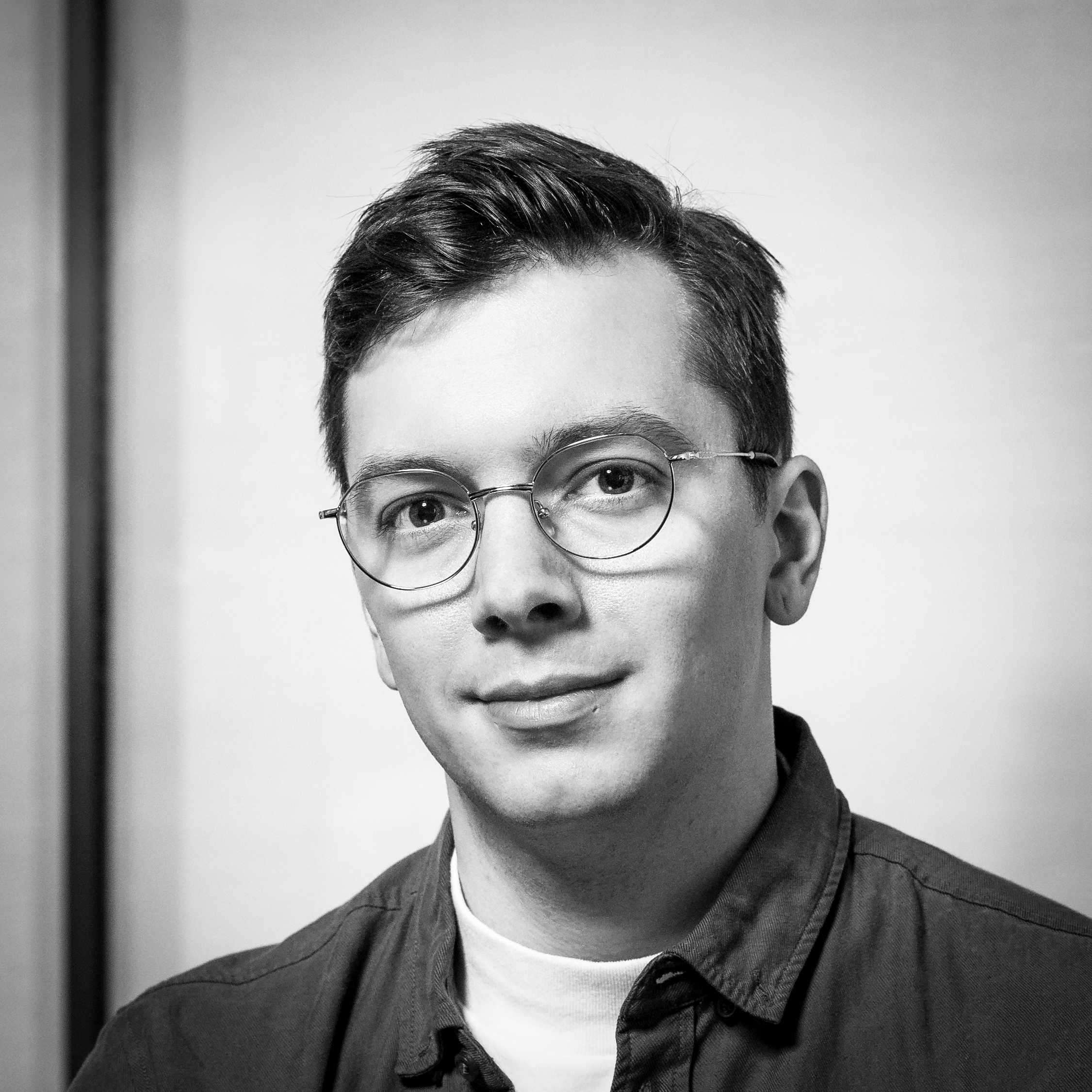 Black and white, head and shoulders photographic portrait of Ezra Miles.