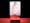 Photograph of a red cube on a red and black background. A crocodile clip is holding a portrait image of a largely naked person with red lipstick and white thong, on a white background.