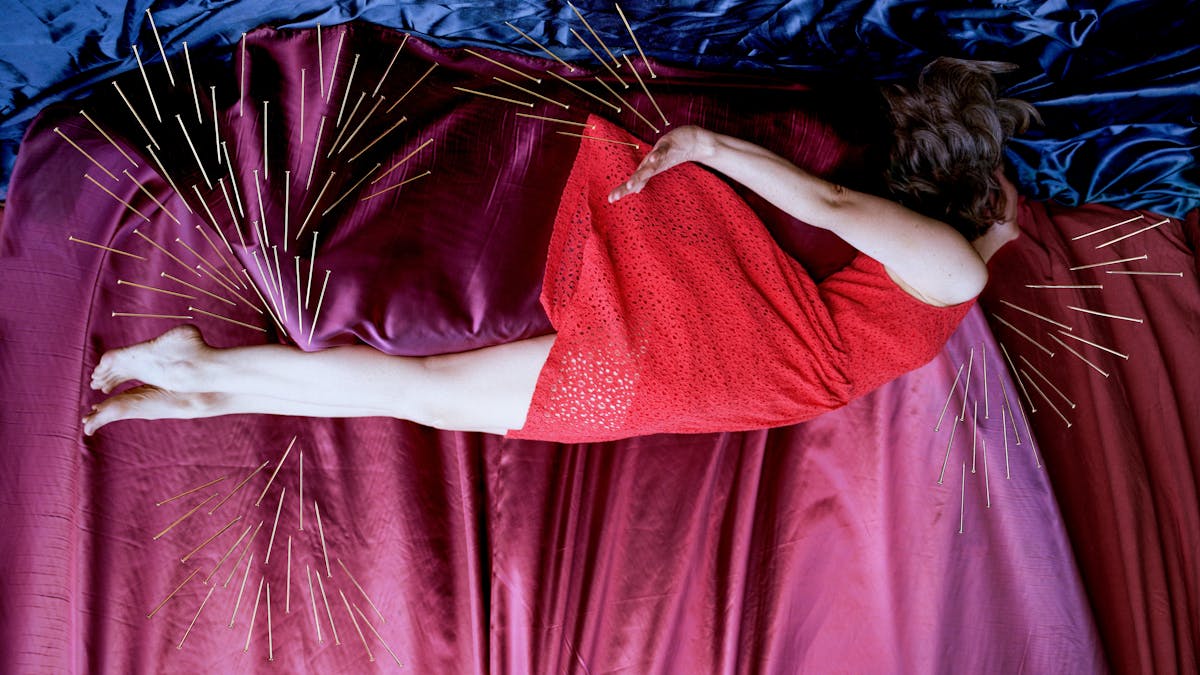 Artwork created with a colour photographic print of a female figure in a bright red dress, set against a purple and blue draped silk background. She is lying horizontally in the frame, face down, caught as if in mid fall.  Her hair and dress are blown upwards, toes and fingers outstretched. Her face is obscured by her hair. Her body is surrounded by groups of dress pins, laid on top of the photographic print. The pins are arranged as if they are a flight of arrows directed at her body. One group attacks her legs from underneath, another from above. A separate group flies towards her neck and chest.