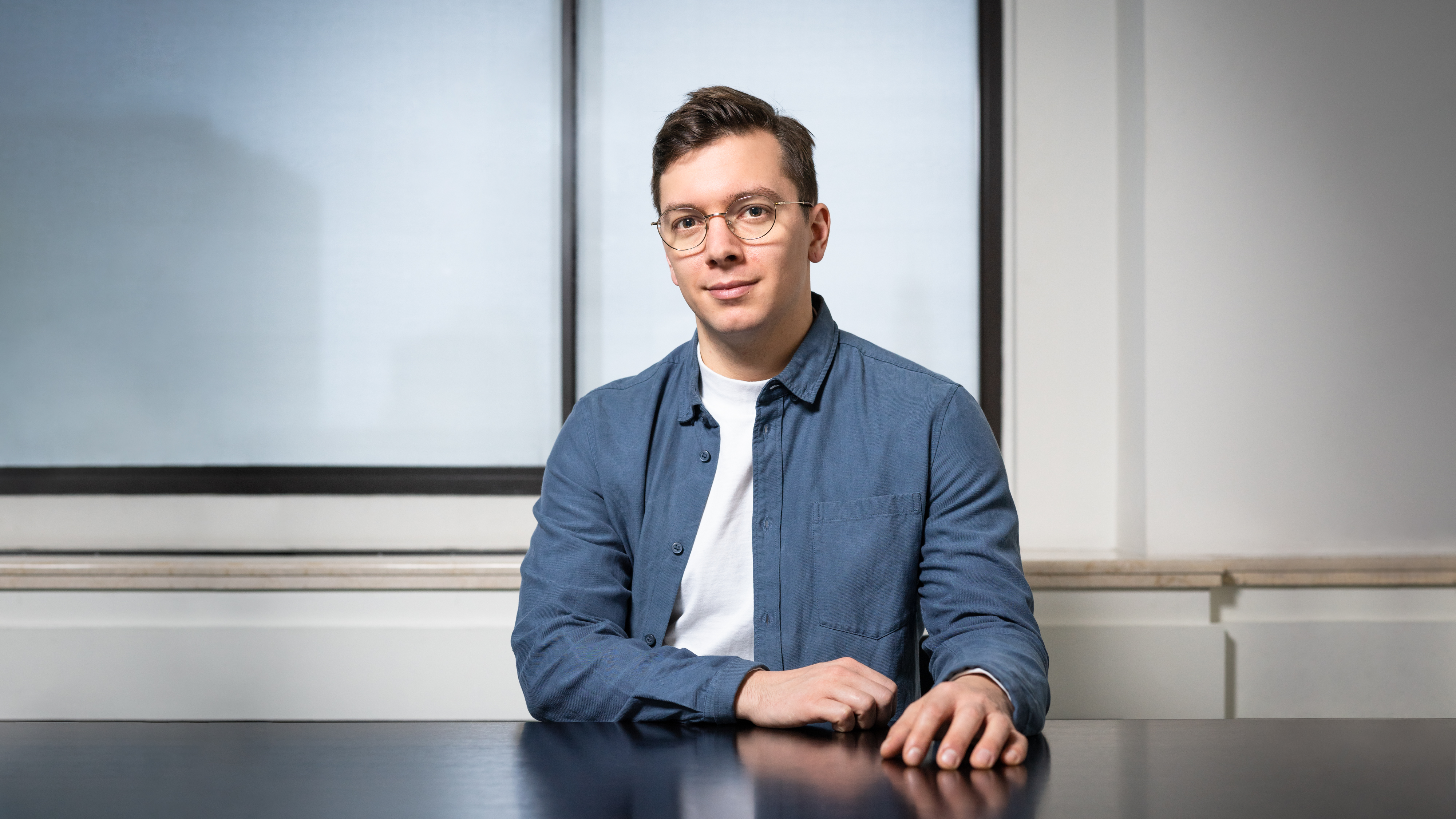 Portrait of Ezra Miles seated at a table.