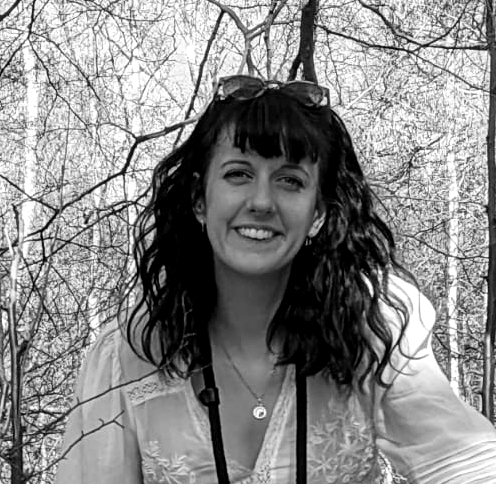 Head and shoulders black and white photograph of Kim Walker with woodland in the background