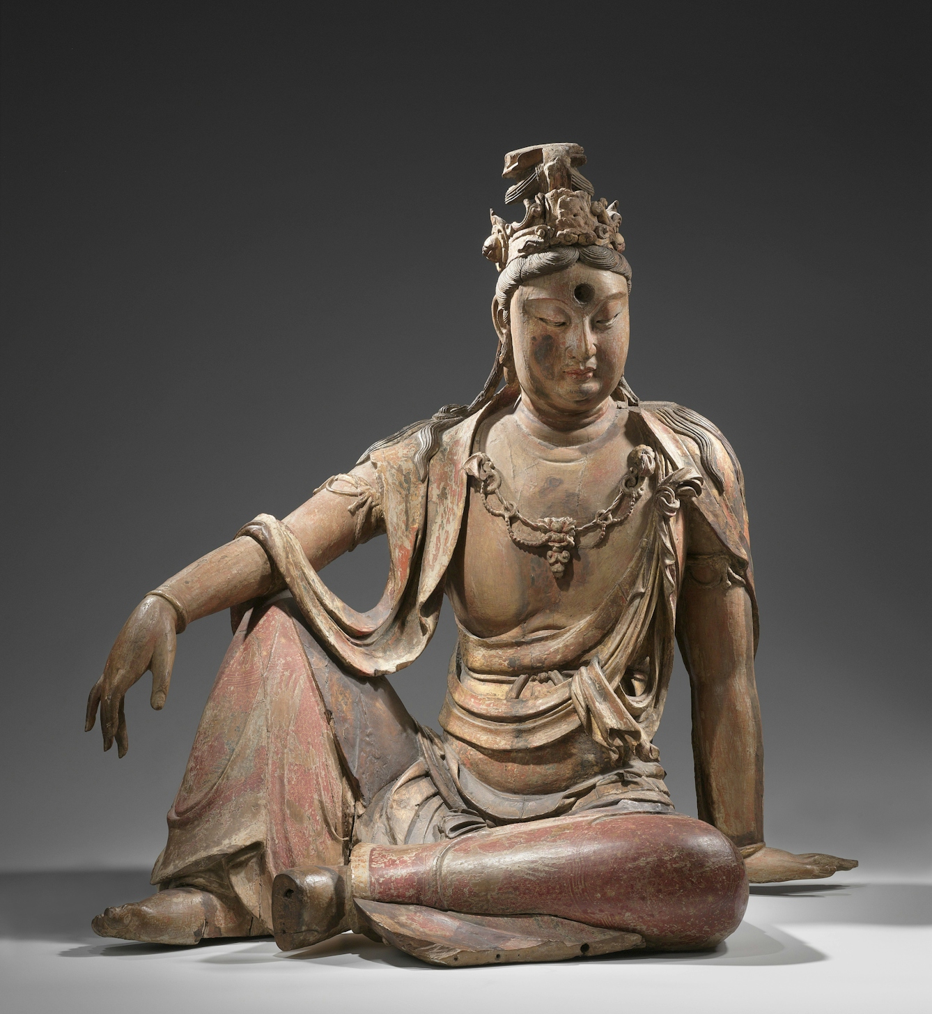 Figurine of seated figure, looking downward in contemplation.