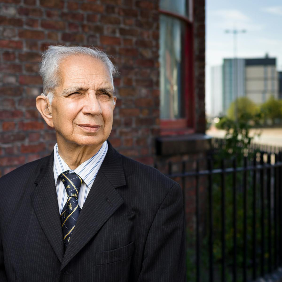Photographic portrait of Dr Shiv Pande outside his former GP surgery.