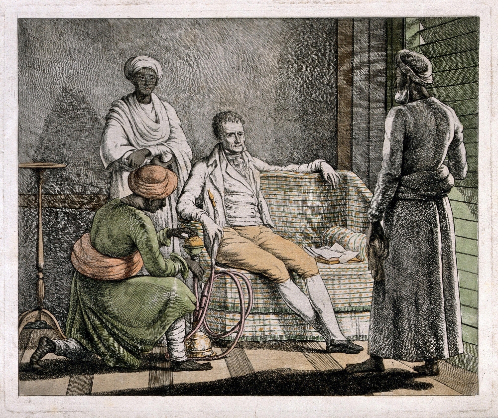 A seated European man smoking a hookah while attended by his hookah bardar and two other Indian servants