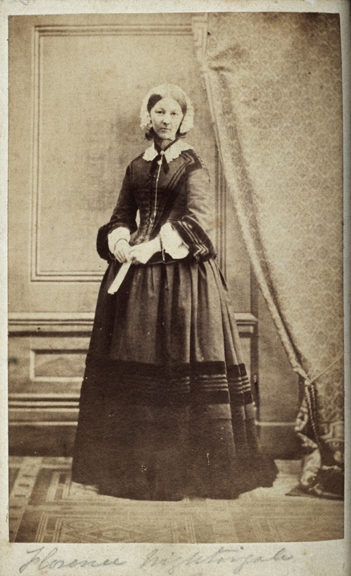 A black and white portrait of Florence Nightingale, wearing a full length dress and bonnet.