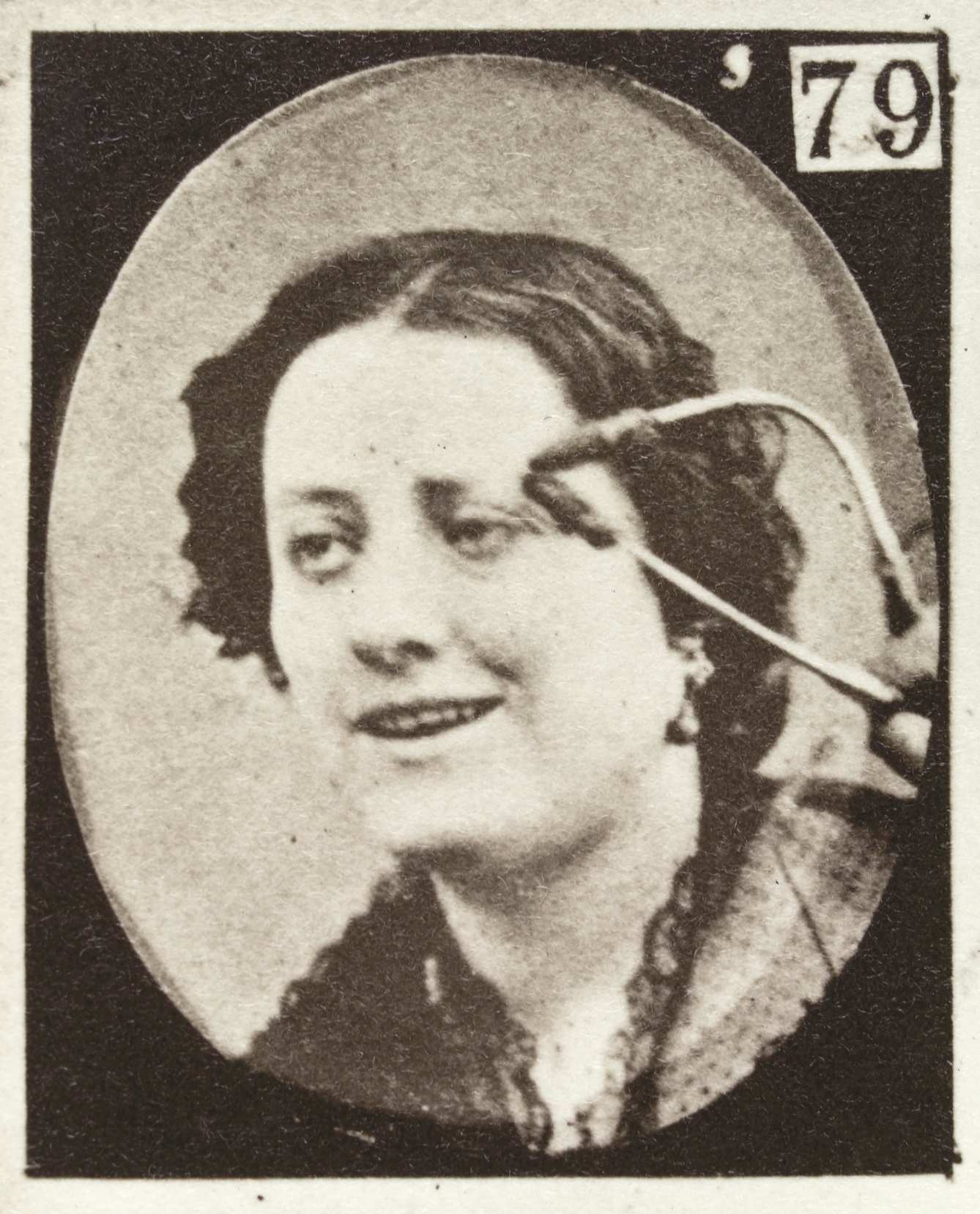 Photograph of a woman's face electrically stimulated by electrodes to show joy