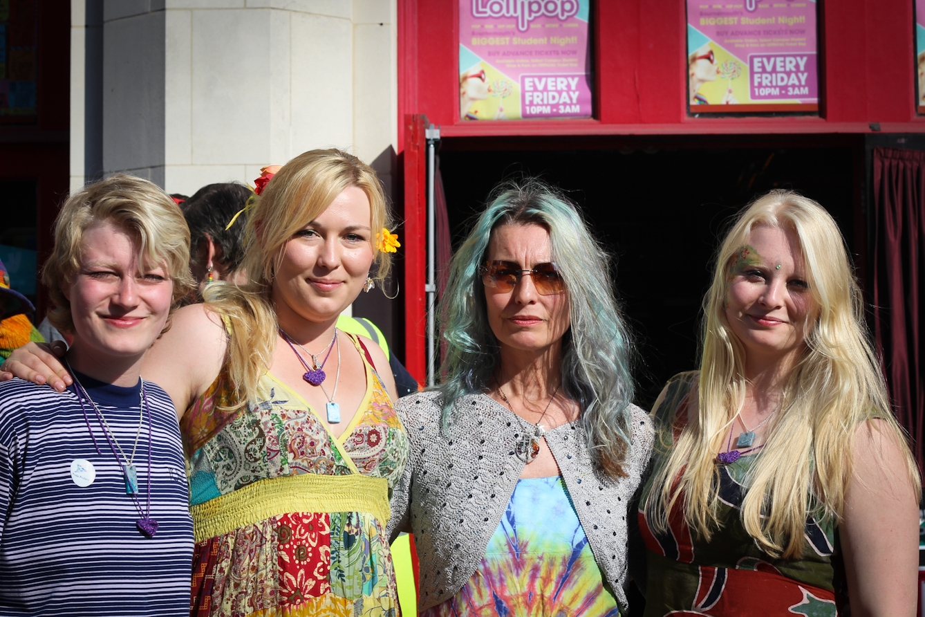 Photograph of four women standing side by side looking towards the camera.