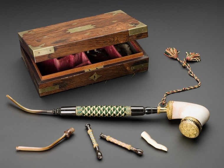 Image of slightly open wooden box with pipes for smoking laid in front of it.