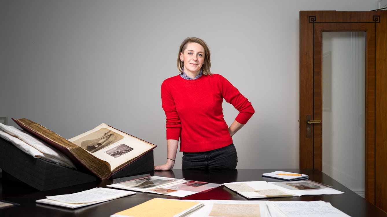 Katherine Hubbard standing behind a table with archive materials on it