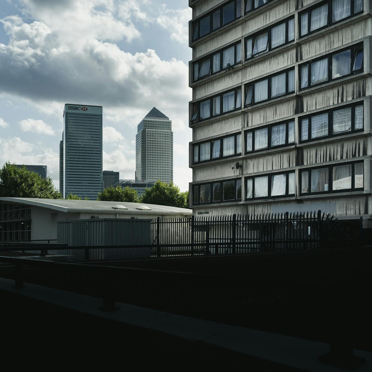 Photograph of a view towards Canary Wharf with a section of a council high rise block of flats in the foreground.