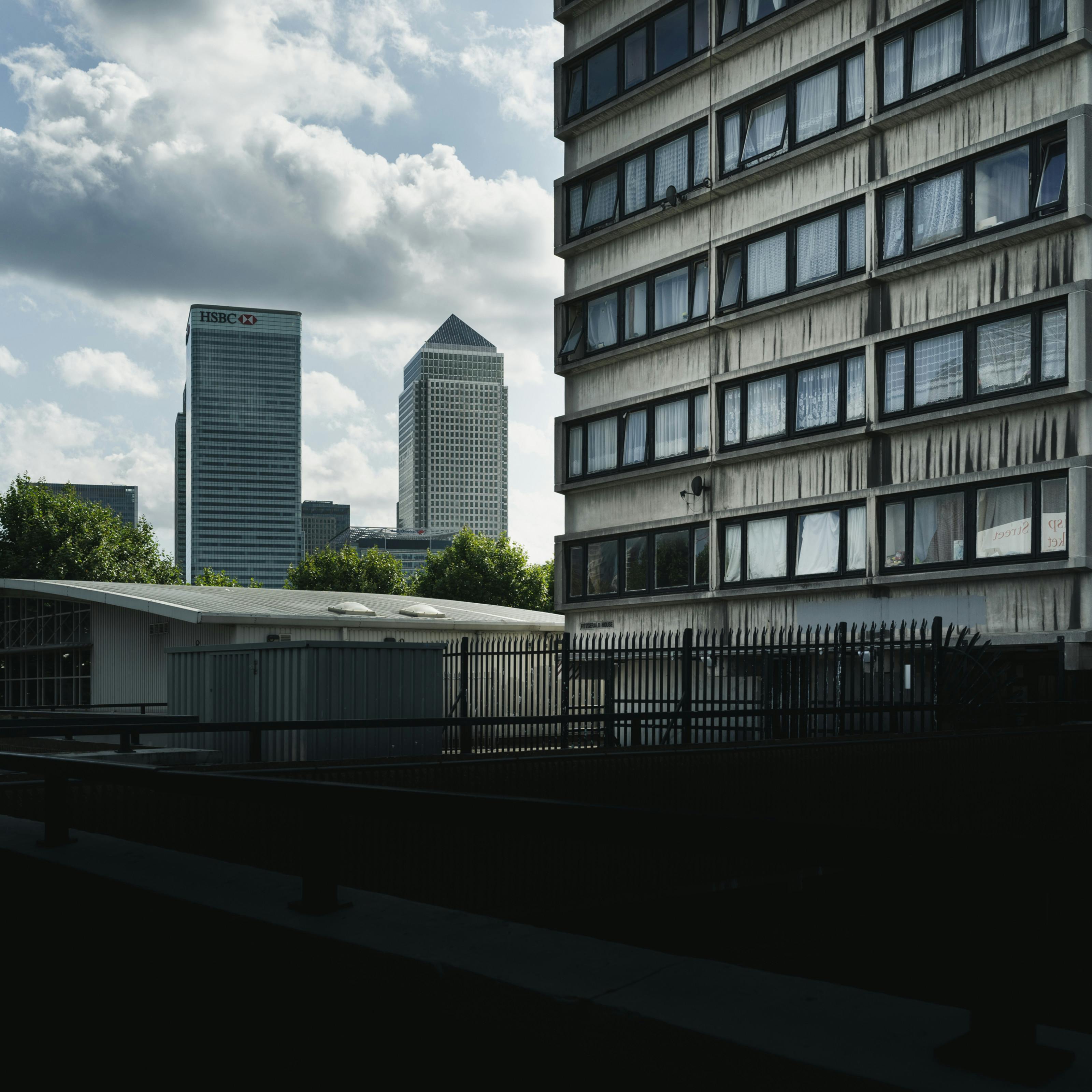 Photograph of a view towards Canary Wharf with a section of a council high rise block of flats in the foreground.