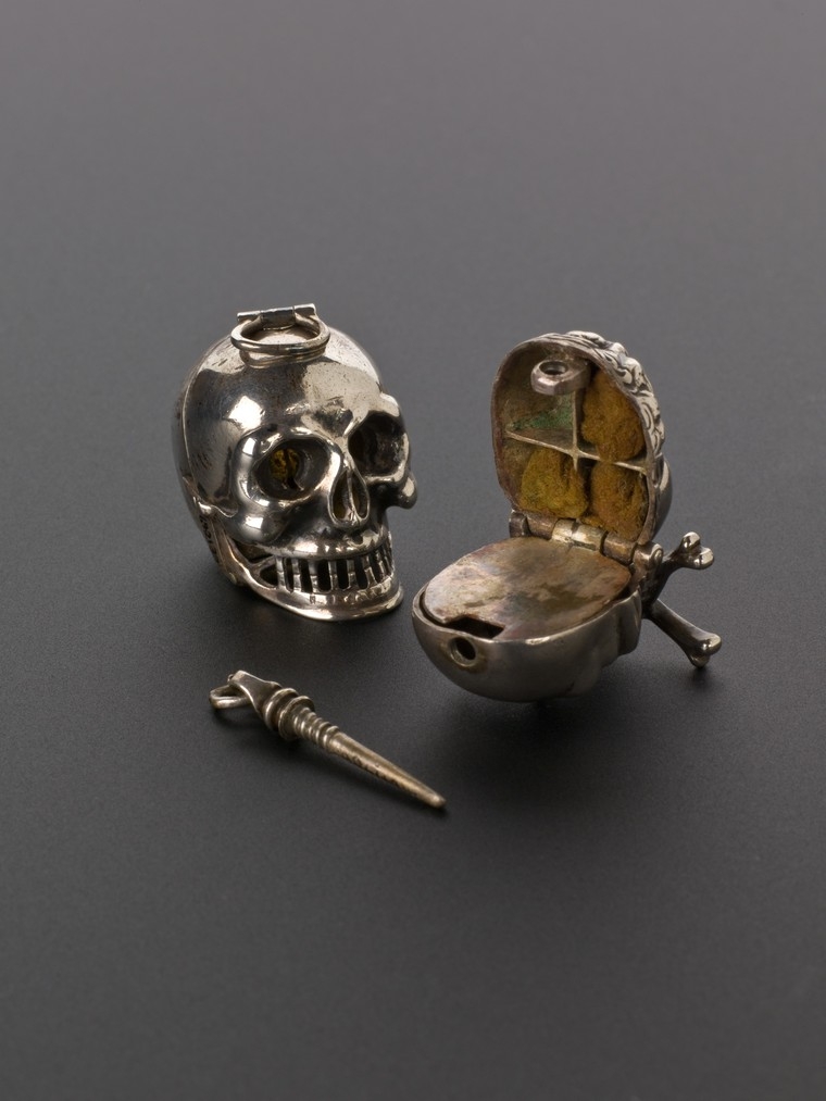 Image of a small silver vinegar container in the shape of a skull.