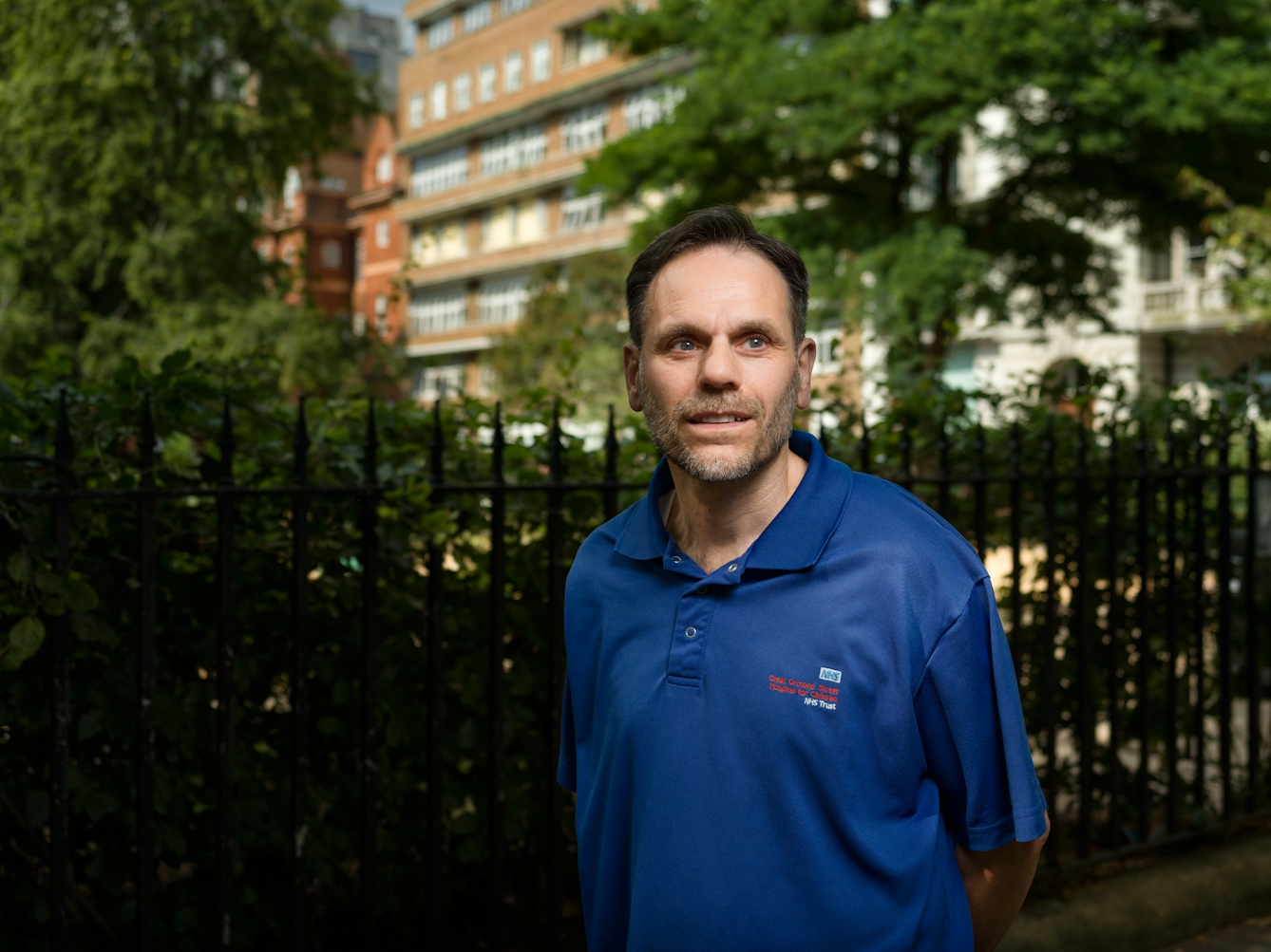 Photographic portrait of Adrian Godbold, a hospital porter, outside Great Ormond Street Hospital, London.