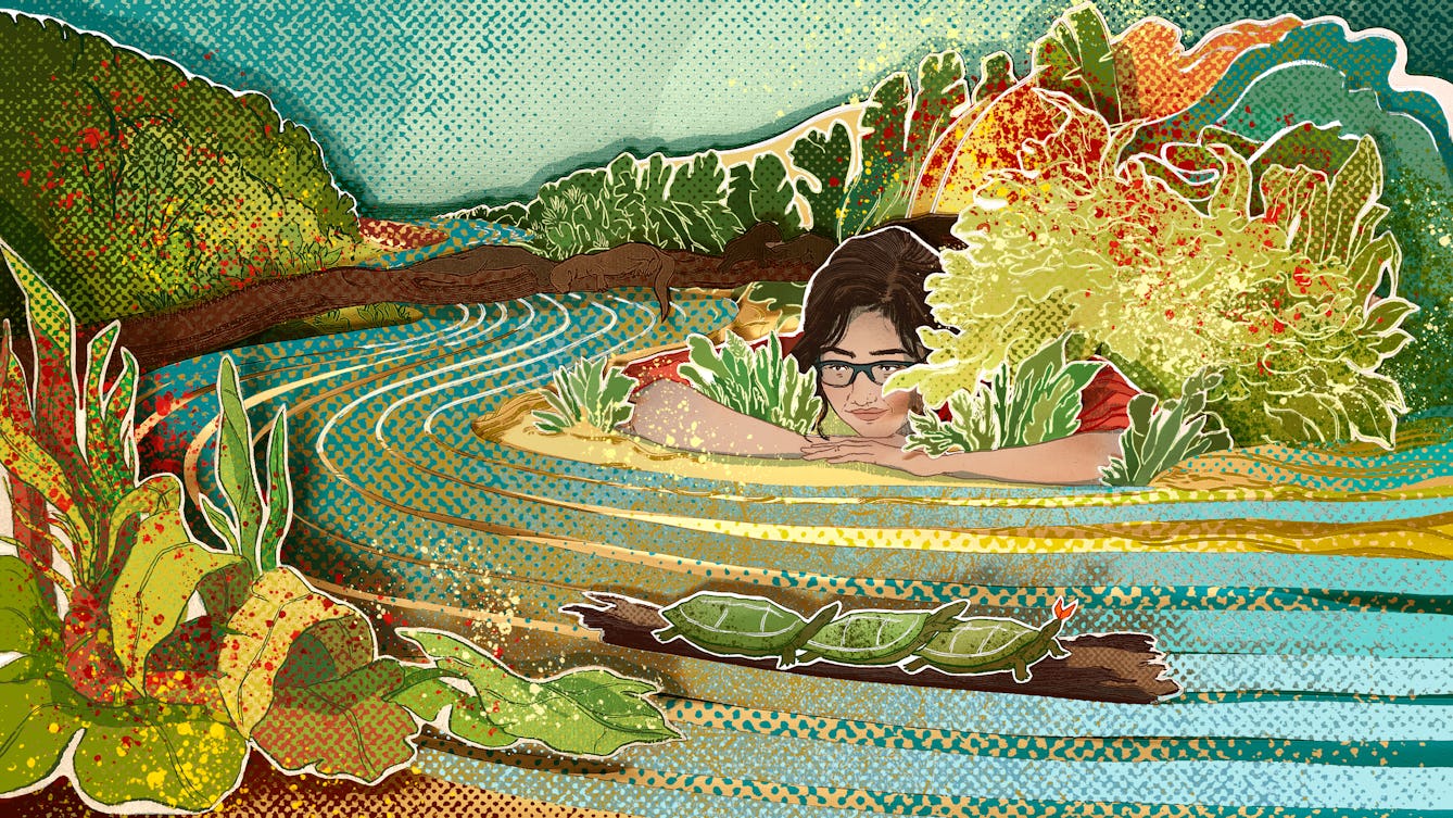 Photograph of a papercut 3D artwork. The image shows a meandering mottled blue and yellow river with white and gold brush strokes indicating the river’s curvature. Surrounding the different bends of the river are plants and shrubbery of various shades of green with red and yellow paint splatters. There is a brunette girl wearing glasses resting with her head in her hands near the river bank.  Four brown otters are shown resting and playing on a branch outstretched across the river. Three tortoises are piled on top of a floating log, travelling downstream. 