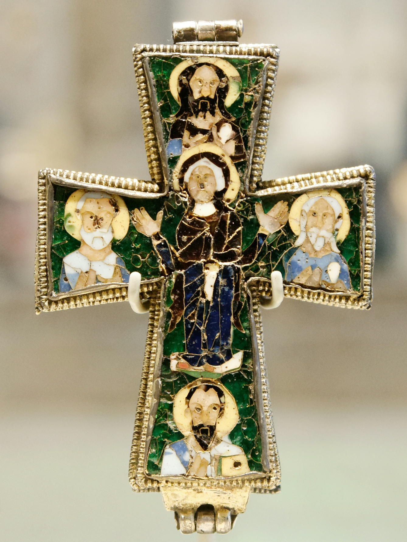 Colour photograph of a gold cross with colourful enamel showing the praying Virgin Mary surrounded by Saints John, Peter, Andrew and Paul.