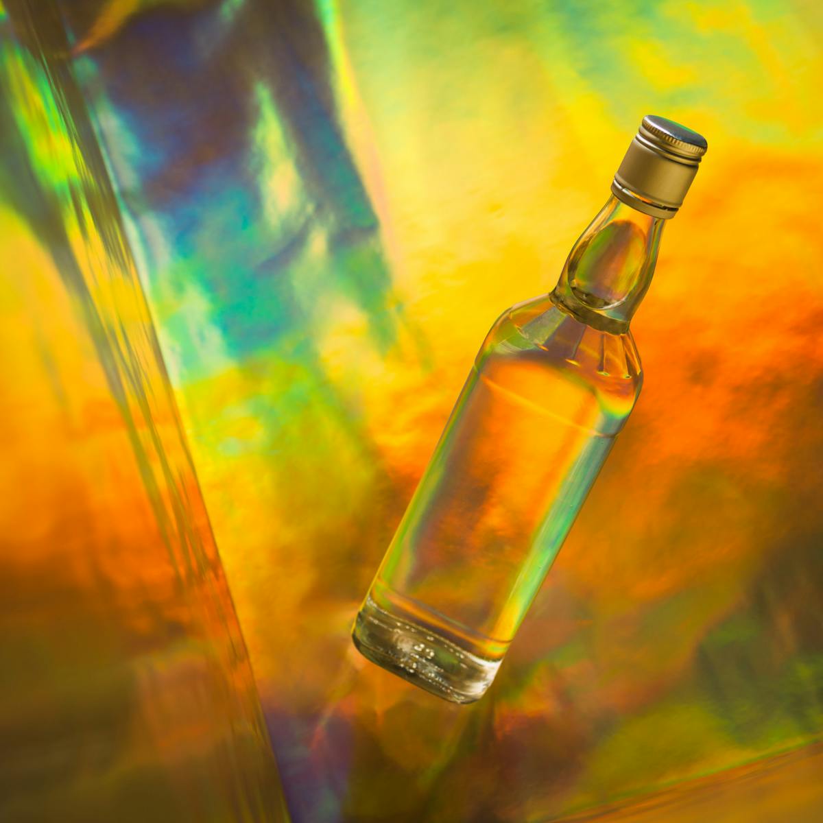 Photograph of an alcoholic spirit bottle on a colourful background.