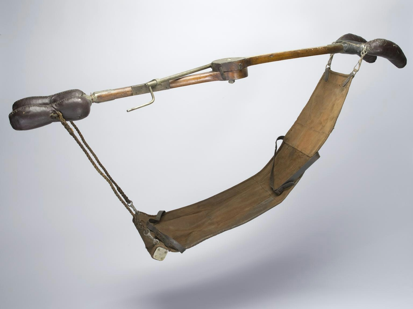 Image of stretcher with wooden rod and ends for holding.