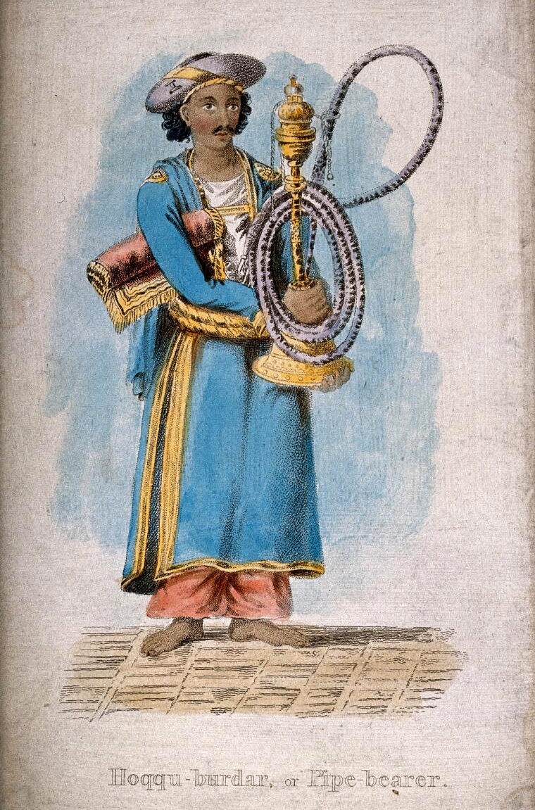 A hookah-bardar or manervant responsible for the hookah pipe. He is standing holding a large hookah with a serpentine pipe and a small mat rolled up under his arm
