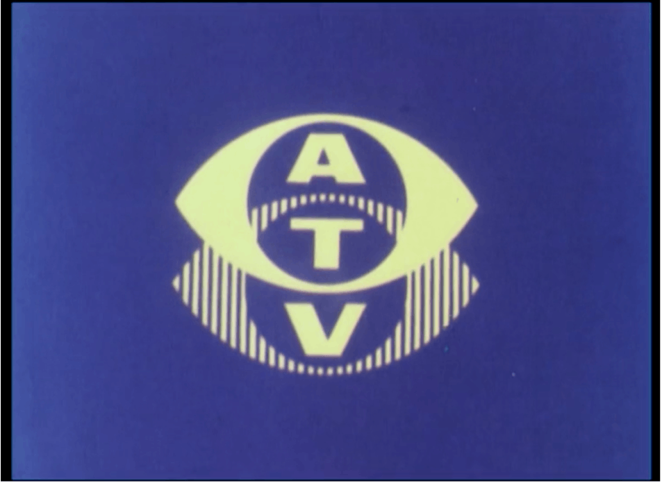 Film still of a yellow logo on a blue background with the acronym 'ATV' shown vertically through the centre.
