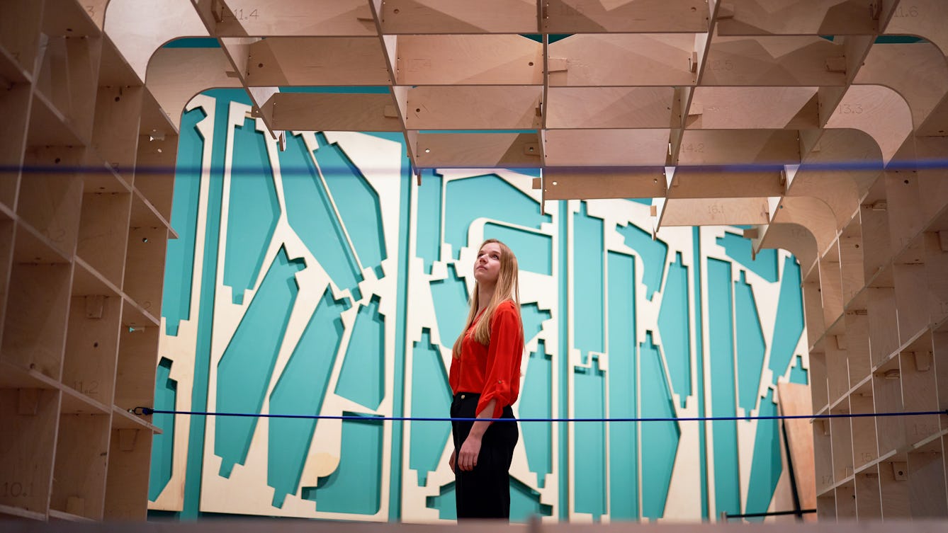 Photograph of a visitor exploring the exhibition, The Global Clinic at Wellcome Collection.