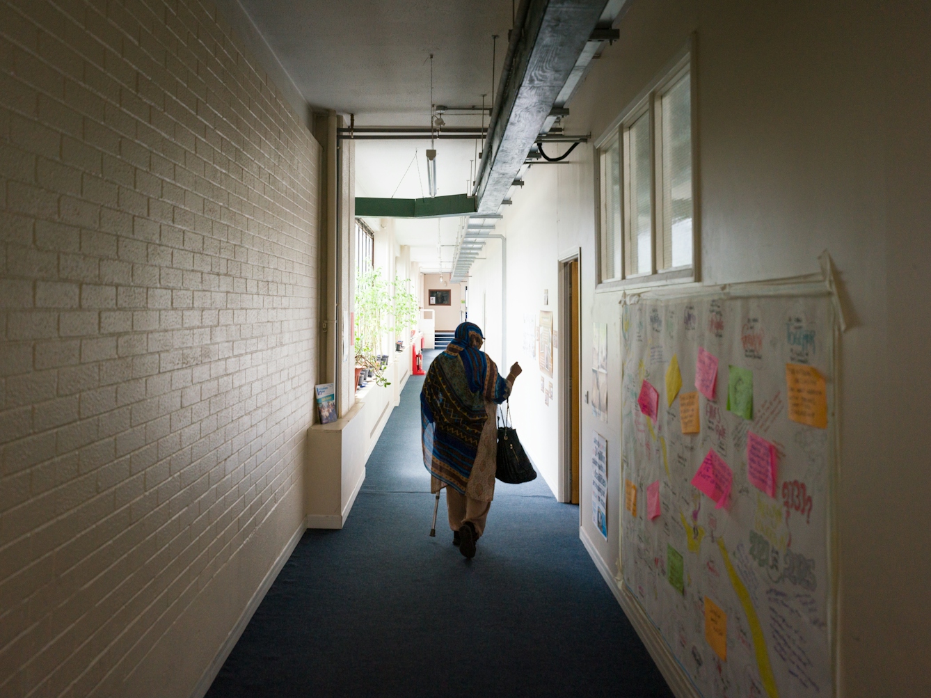 Photograph of Sarifa Patel walking down a corridor.