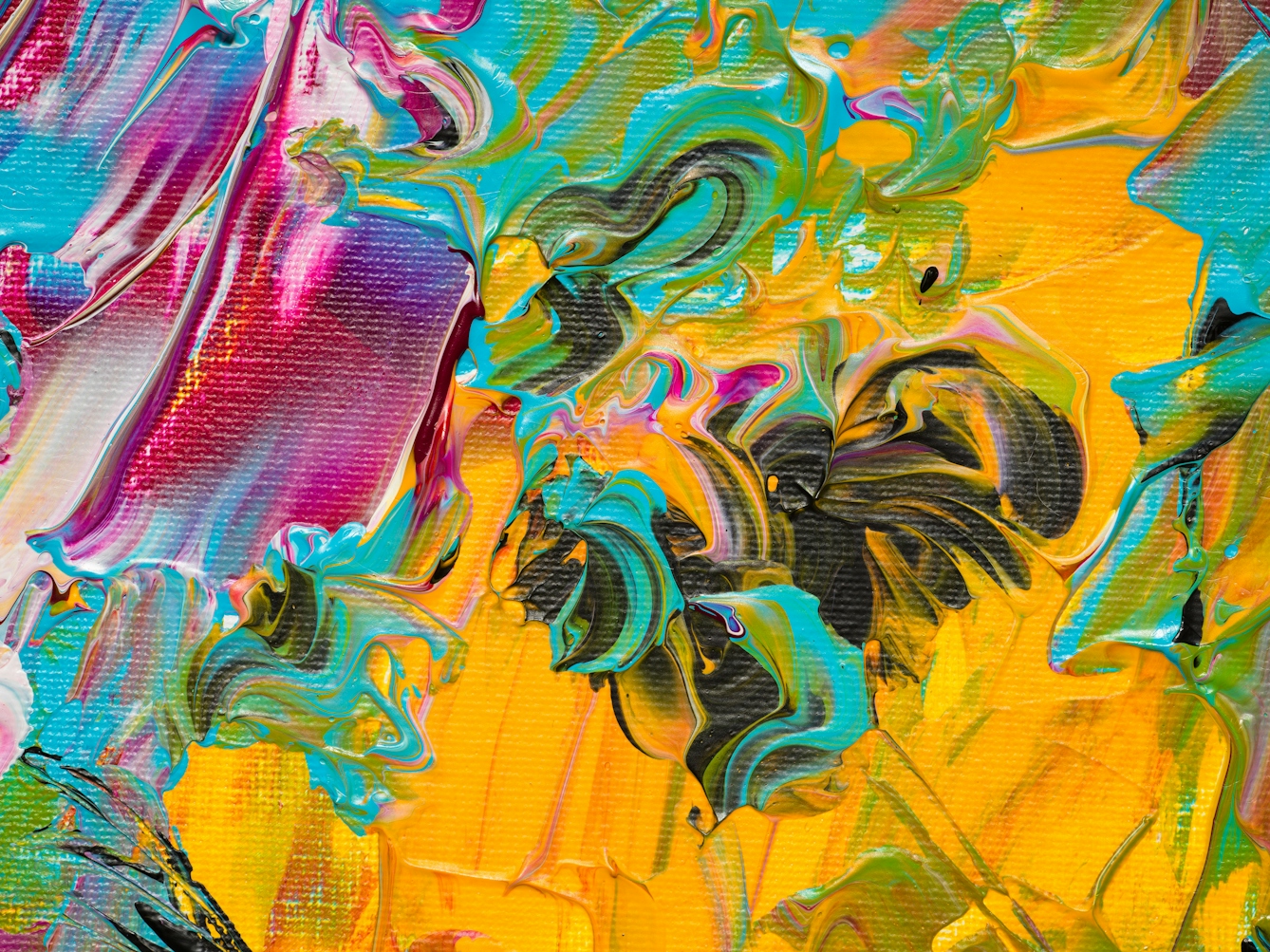 Photograph of close-up detail of a larger abstract  expressionist painting  utilising acrylic paint on a rectangular canvas in landscape orientation. A vast majority of the canvas surface contains many scattered, complex and confusing marks and gestures of vibrant and colourful tones - including yellow, pink, orange, turquoise, white. It's akin to a frenetic and overwhelming scene of repeated surprises and shocks.