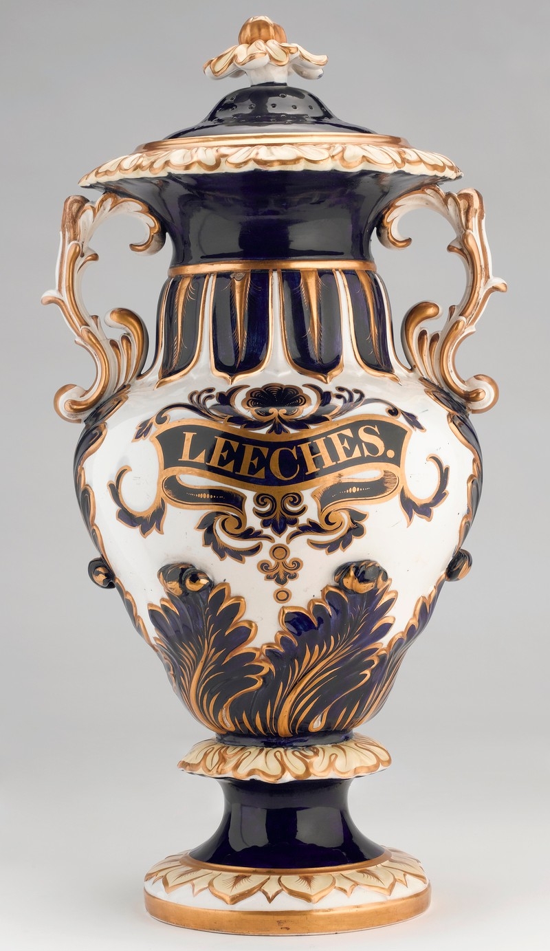 Photo of ornate jar with black, gold and white decoration. In the middle, it says 'leeches'.