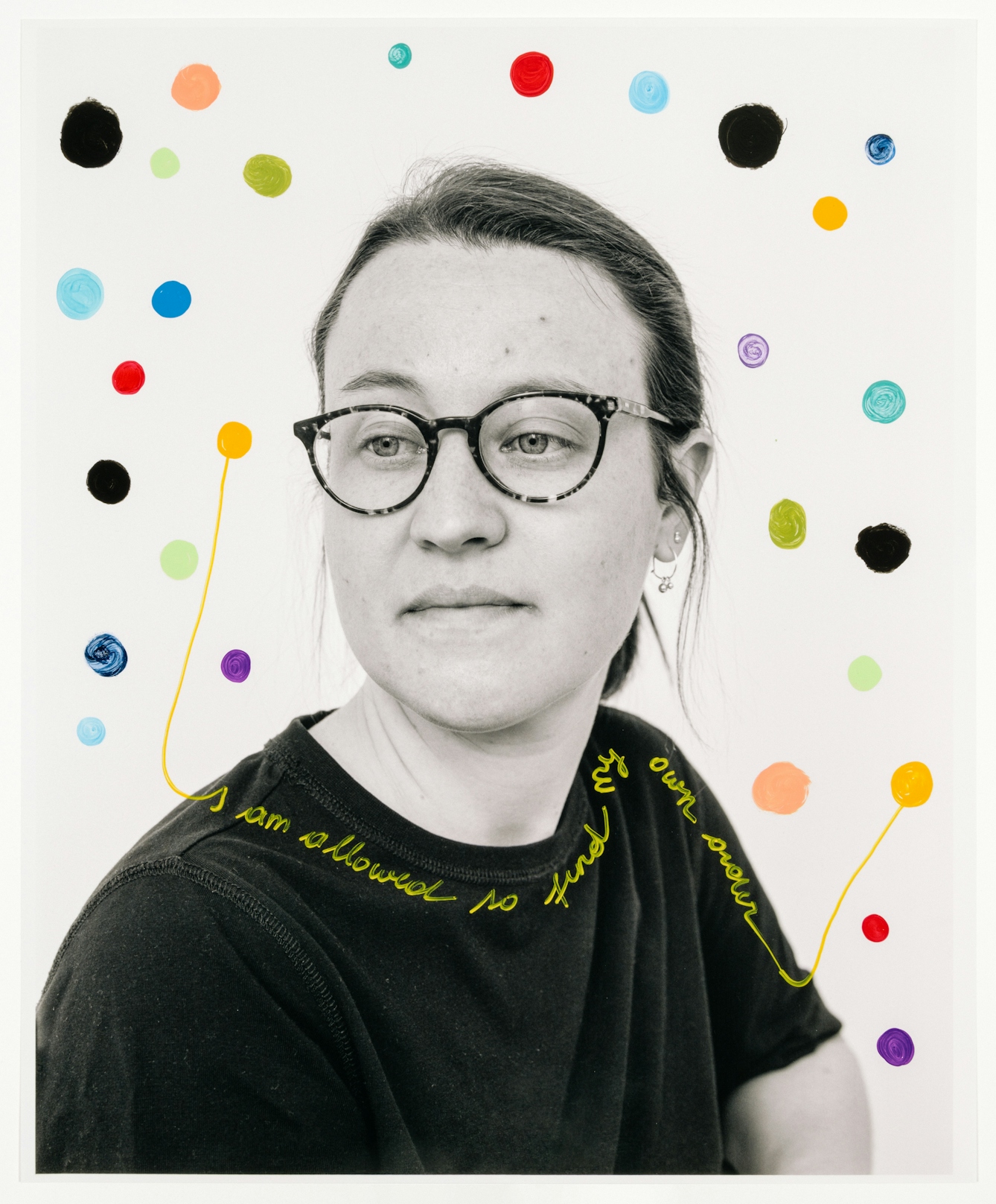 Head and shoulders photograph of a woman with her body facing to the right of the frame whereas her gaze is off to the left.  A number of colourful dots are hand-drawn over the top of the portrait.  Around the woman’s neckline and shoulder the words ‘I am allowed to find my own order”.
