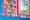 A close up photograph showing the corner of a large colourful mural on a bright pink coloured section of wall. The mural is comprised of small squares featuring simple colourful graphics including piano keys, clothed torsos and picture frames. Similar images run along the top of a narrow cupboard painted blue below. A white PVC window is visible on the right-hand side of the image.