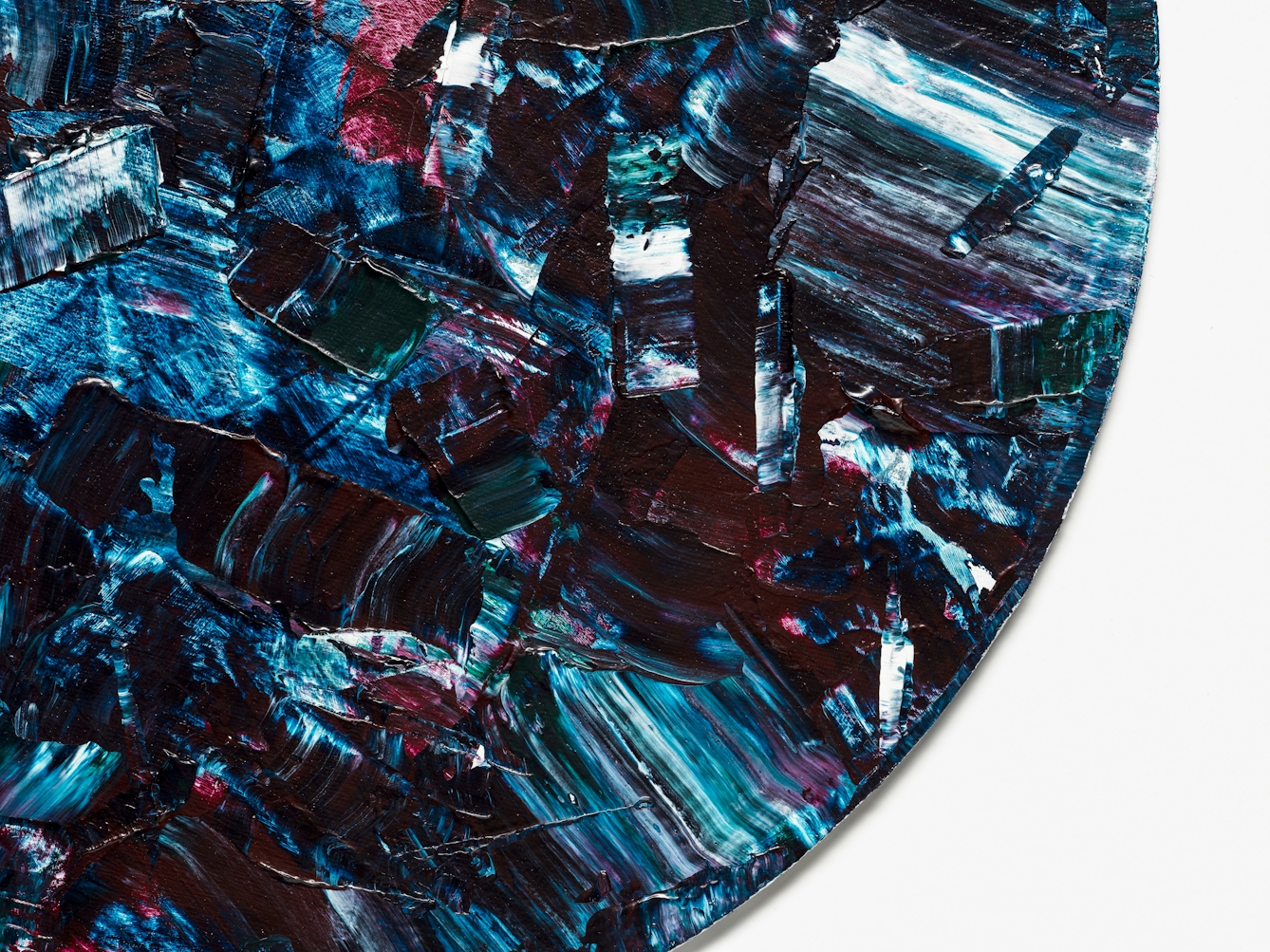 Detail from a larger abstract expressionist painting utilising acrylic paint on a circular canvas, titled 'Dissonant'. This detail reveals the bottom right curve of the circular canvas. The vast majority of the canvas surface contains sharp disconnected marks of blues, purples, turquoise, white and scarlet. The marks are short and random in direction and length. Together they make up a scene of fractured and abrupt expression, yet with a compelling beauty.