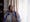 Photographic portrait of Sarifa Patel sitting next to the window in her living room.
