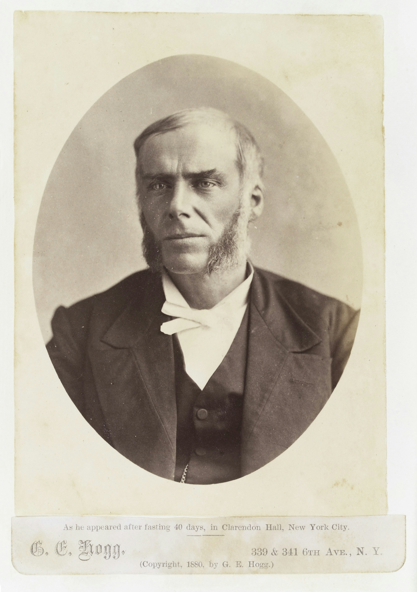 Black and white portrait photograph of a white man with large side burns.