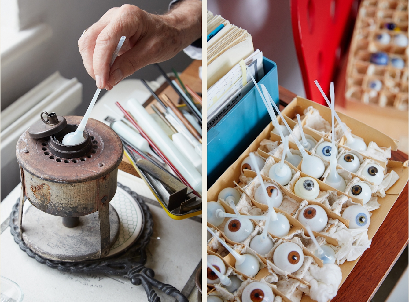 A photographic diptych. The image on the right shows a hand holding a white glass tube with a sphere at one end, into a metal contraption standing on a workbench. The image on the right shows a close-up detail of a partitioned cardboard box containing various glass eyes of differing coloured irises, some with a long white glass tube still attached.