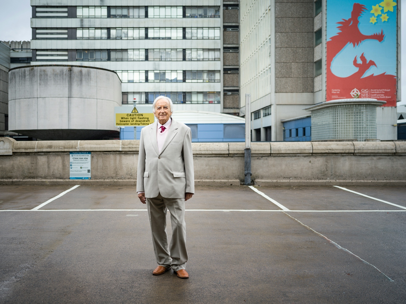 Photographic full length portrait of Morgan David Enoch, psychiatrist, outside the University Hospital of Wales, Cardiff.
