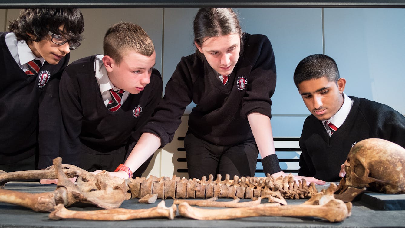 Photograph of young students examining a skeleton as part of a Wellcome Collection school study day.