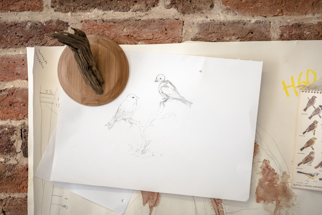 Pencil drawings and plans pinned to the walls of Jazmine's studio.