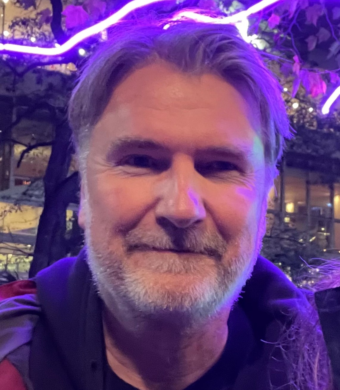 A headshot photo of a man with gray hair and beard