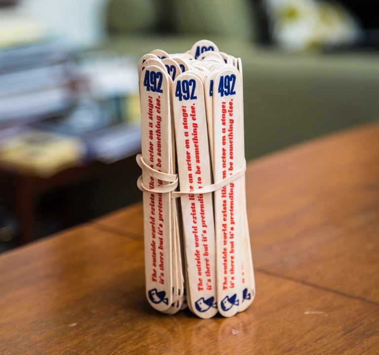 A bundle of wooden lollipop sticks that have been printed with an extract from The Book of Disquiet.