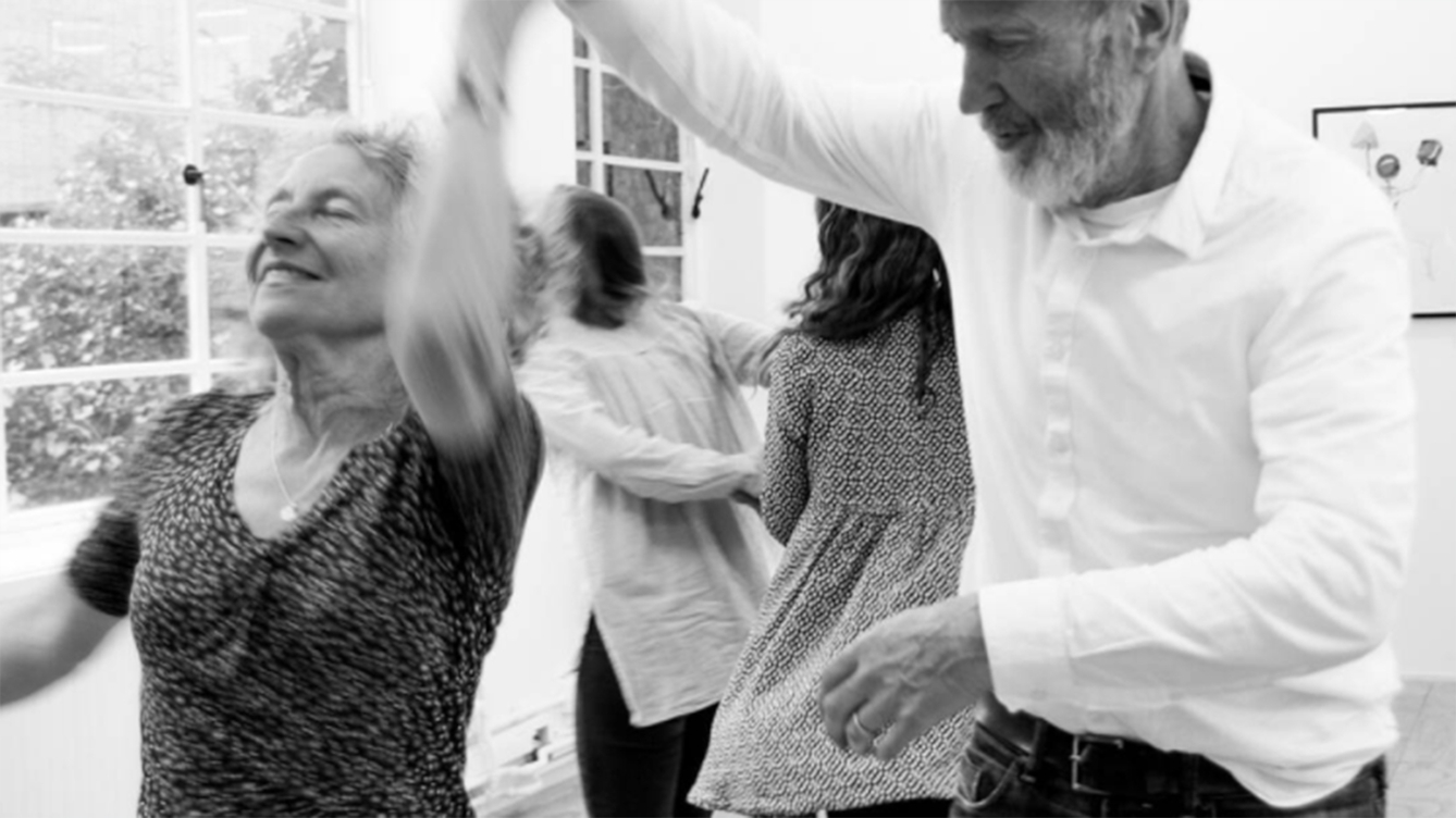 A black and white of photograph of an older man and woman dancing.