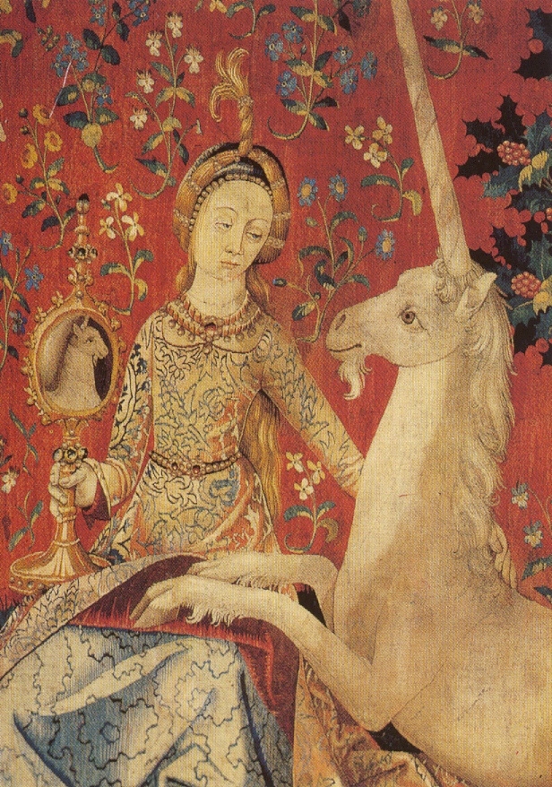 Medieval tapestry depicting a woman holding up a mirror and a white unicorn gazing upon its reflection in the glass. 