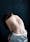 Photograph of the back of a woman seated on a stool, naked from the waist up. She is leant over slightly to the left. Along her spine is the visible scar from an operation to correct for scoliosis.