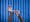 Photograph of a pair of hands cradling a set of forceps. Photographed against a background of blue antibacterial clinical curtains.